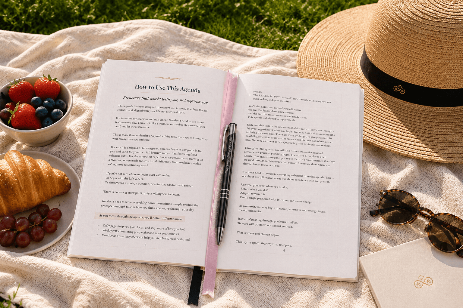 Open book with pen, croissant, and fruit on a picnic blanket outdoors, describing 'How to Use this Agenda'